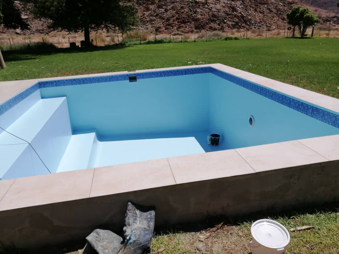 Clear blue maintained pool with mosaic waterline tiling