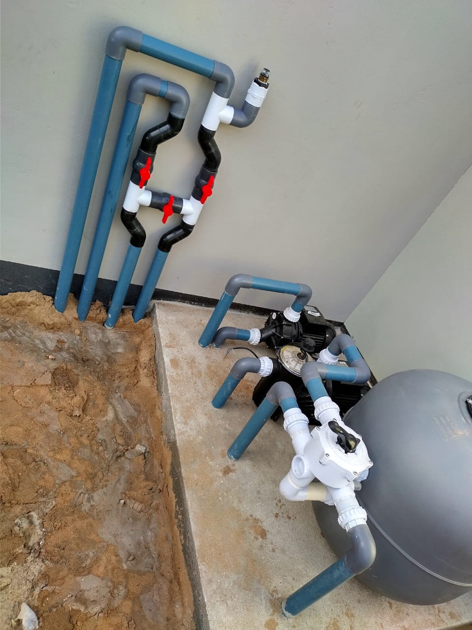 Newly installed pool pump, filter and pipework in a plant room